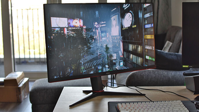 The AOC U28G2XU/BK gaming monitor on a desk, running Ghostwire: Tokyo.