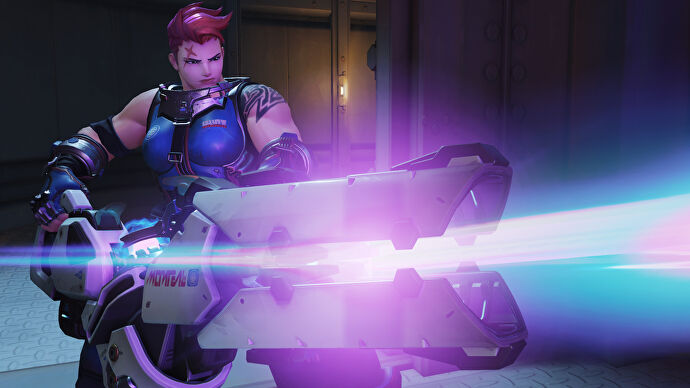 Zarya, a hero in Overwatch 2, fires a beam with her weapon off-camera.