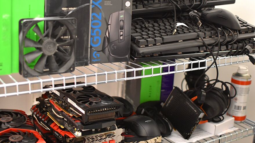 Two shelves stacked with various gaming PC components and peripherals.